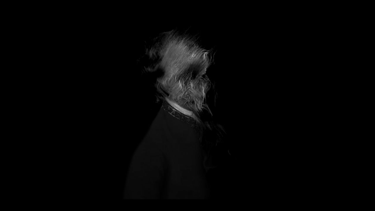 A figure whose head dissolves into strands of smoke, on black.